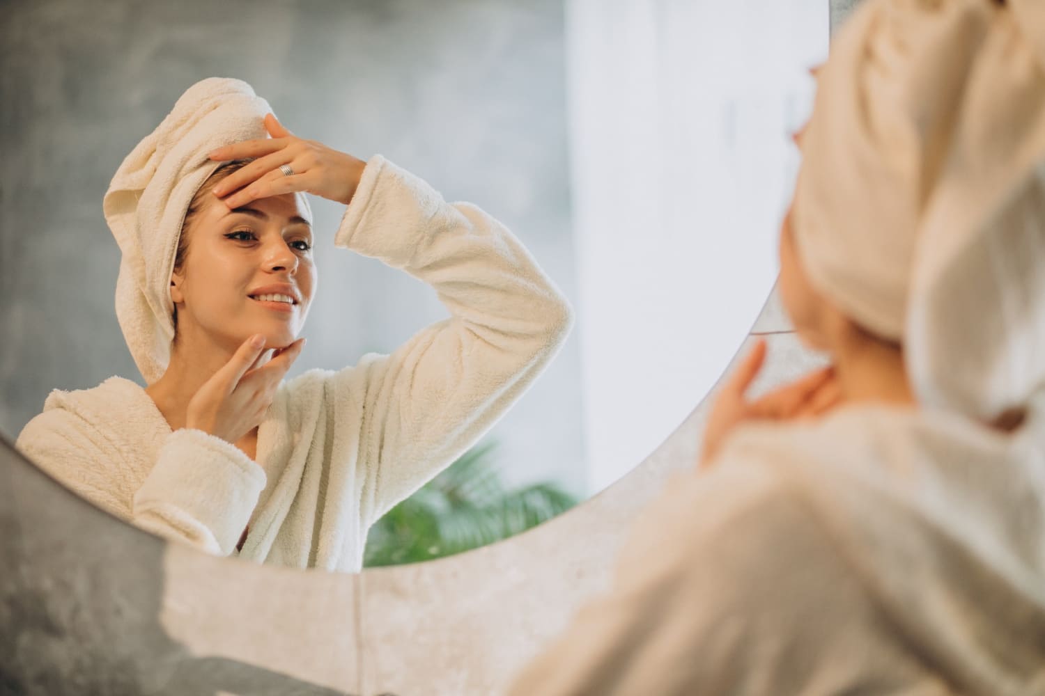 Женщина перед зеркалом обрабатывает кожу лица